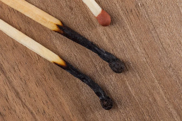 Burned wooden matches sticks on a wooden table background.