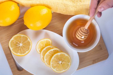 Ahşap mutfak tahtası limon ve bal ayı beyaz seramik kase tatlım.