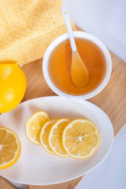 bir beyaz seramik kase kaşık ve limon ahşap mutfak tahtası ile tatlım.