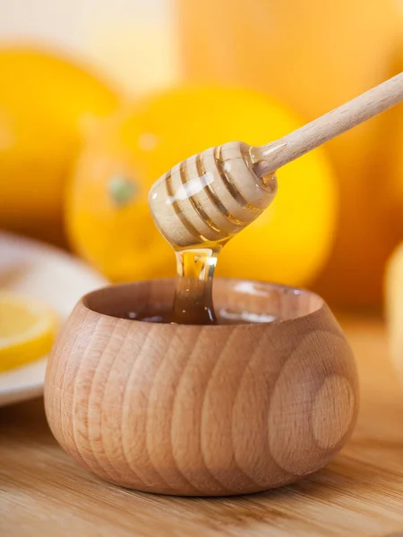 蜂蜜蜂蜜ディッパーとレモンの木のキッチン ボード木製ボウルで — ストック写真