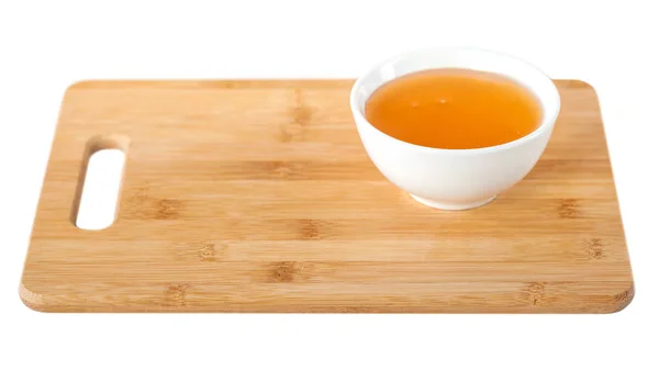 蜂蜜在一个白色陶瓷碗在木制厨房板上 白色背景 — 图库照片