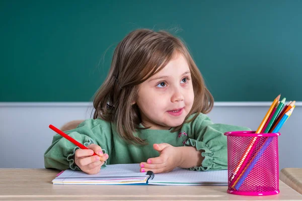 灰色机と描画の教室で座っている小さなかわいい女の子 — ストック写真