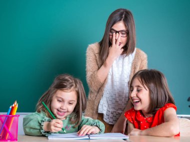 Ablam o içinde a defter çizer gibi küçük kız kardeşi bakıyor.