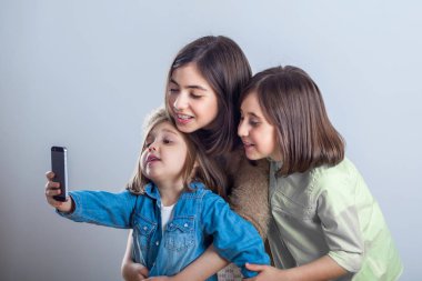 poz ve stüdyoda selfies alarak üç kız kardeş.