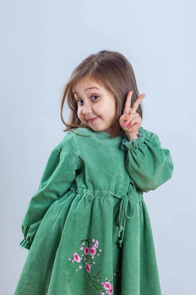 スタジオでのカメラのポーズの緑のドレスの少女 — ストック写真