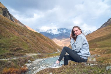 Svaneti, dağ olan, bir dağ arka plan üzerinde güzel kız rahat seyahat ederken.