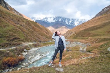 Svaneti, dağ olan, bir dağ arka plan üzerinde güzel kız rahat seyahat ederken.