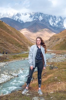 Svaneti, dağ olan, bir dağ arka plan üzerinde güzel kız rahat seyahat ederken.