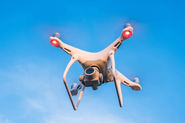 Flying drone with blue sky background.