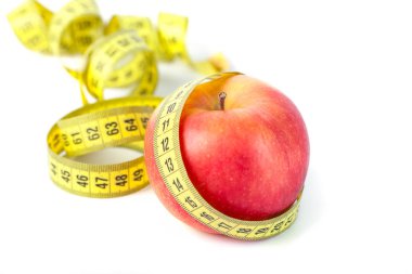 Ölçü bandı beyaz arka planda, sağlıklı beslenme ile kırmızı elma.