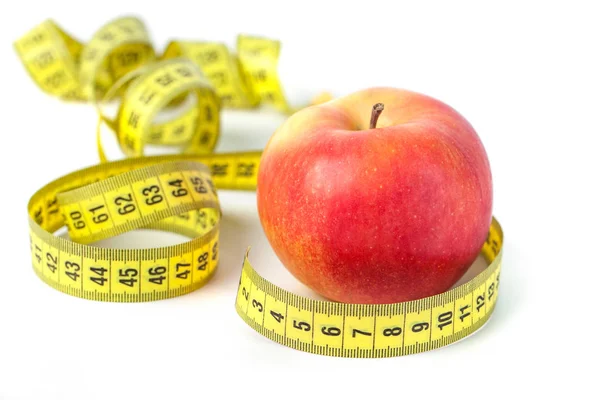 Ölçü bandı beyaz arka planda, sağlıklı beslenme ile kırmızı elma.
