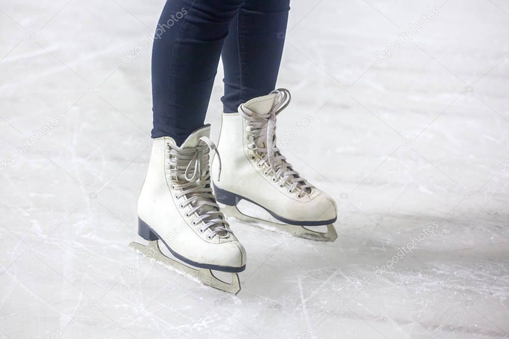 feet on the skates of a person rolling on the ice rink.