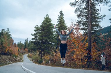güzel genç kız Svaneti de yol sevinç için atlama
