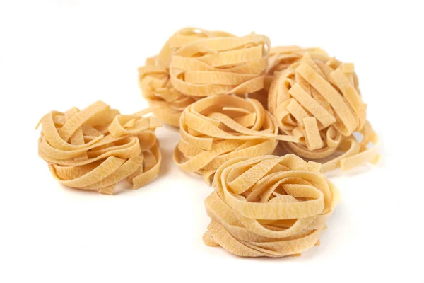 Uncooked nest of tagliatelle Italian pasta isolated on white bac — Stock Photo, Image