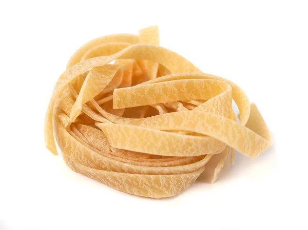 Ongekookt nest van tagliatelle Italiaanse pasta geïsoleerd op witte bac — Stockfoto