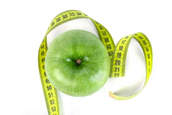 Зеленое яблоко с измерительной лентой на белом фоне — стоковое фото