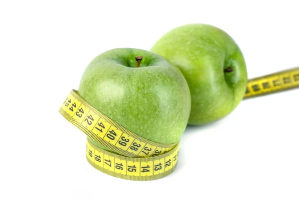 Зеленые яблоки с измерительной лентой на белом фоне — стоковое фото