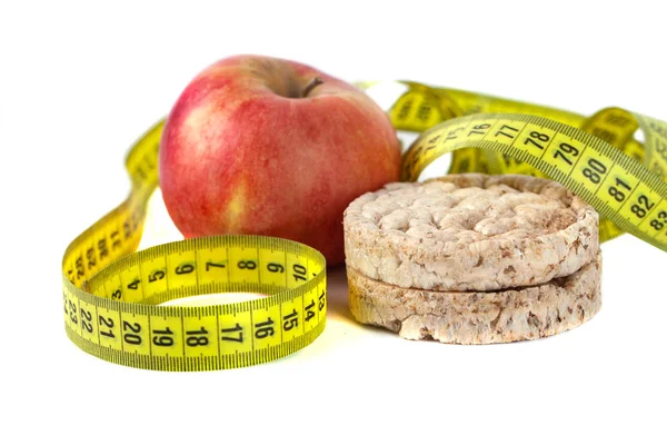 Healthy puffed corn galettes and red apple with measuring tape — Stock Photo, Image