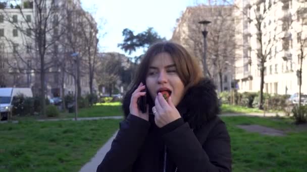 Приваблива Дівчина Розмовляє Телефону Їсть Полуницю Парку — стокове відео