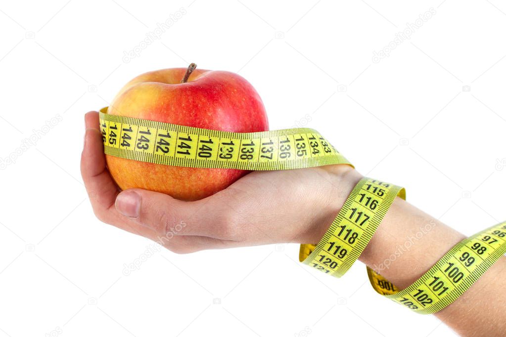 apple in hand with a tape measure on white background