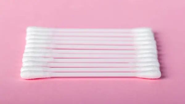 Varas para limpar orelhas em um fundo rosa — Fotografia de Stock