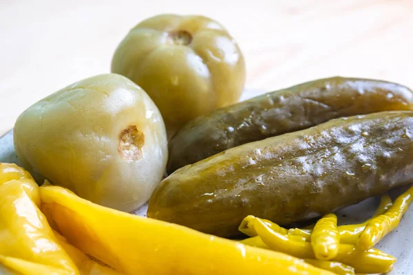 Pickled tomatoes, cucumbers and peppers on the plate — Stock Photo, Image