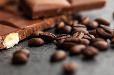 Gri arka planda kahve çekirdekleri ve koyu çikolata sır