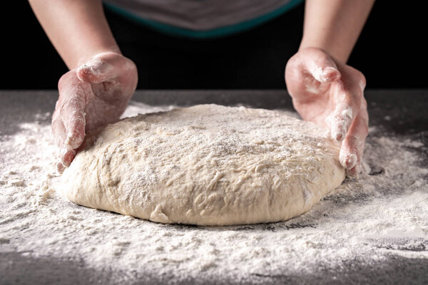 Making dough by female hands at bakery