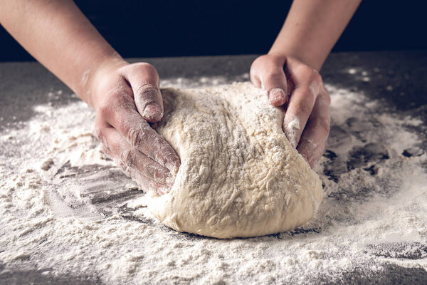 Making dough by female hands at bakery