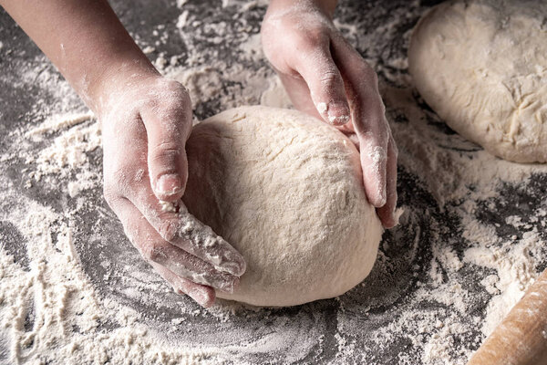 Making dough by female hands at bakery