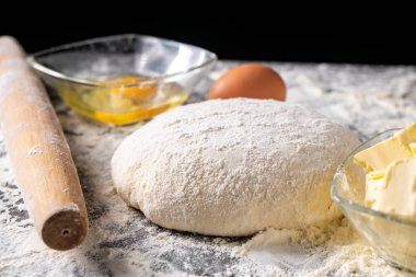 Pişirme tahtasında yumurta, tereyağı ve hamur ile beyaz un