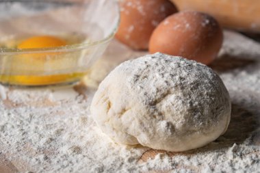 Pişirme tahtasında yumurta, tereyağı ve hamur ile beyaz un