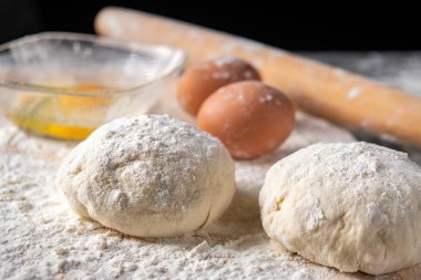 Pişirme tahtasında yumurta, tereyağı ve hamur ile beyaz un