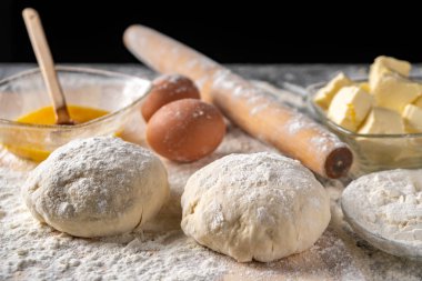 Pişirme tahtasında yumurta, tereyağı ve hamur ile beyaz un