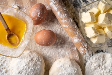 Pişirme tahtasında yumurta, tereyağı ve hamur ile beyaz un