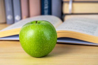 ahşap masada kitap ve yeşil elma