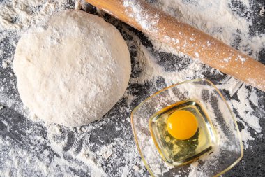 Pişirme tahtasında yumurta, tereyağı ve hamur ile beyaz un