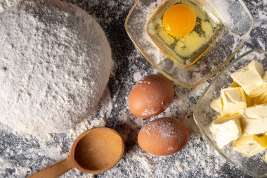 Pişirme tahtasında yumurta, tereyağı ve hamur ile beyaz un