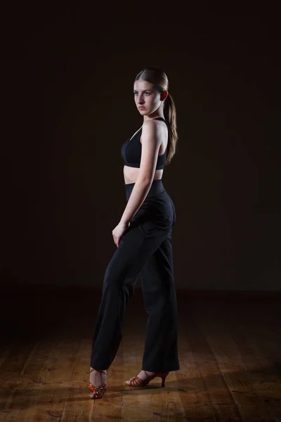 Beautiful girl wearing black sportswear is training in the dance — Stock Photo, Image