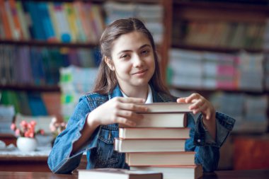 kitap ile kütüphanede oturan güzel kız öğrenci