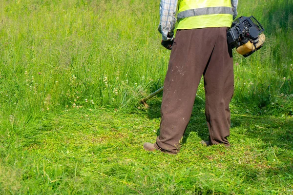 Der Gärtner mäht Gras per Rasenmäher, Rasenpflege — Stockfoto