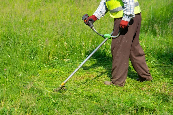 El jardinero cortando hierba por cortacésped, cuidado del césped —  Fotos de Stock