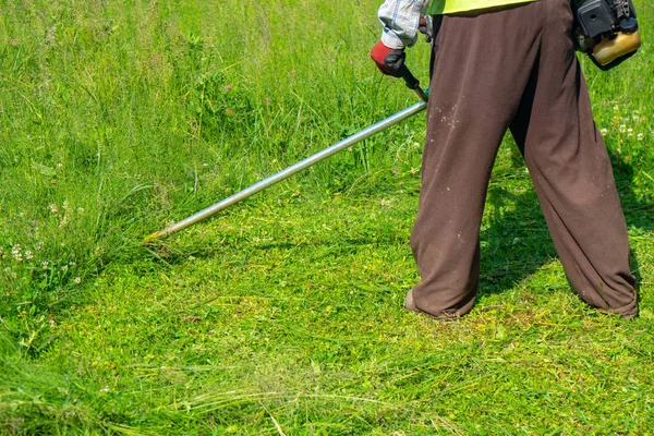 Der Gärtner mäht Gras per Rasenmäher, Rasenpflege — Stockfoto
