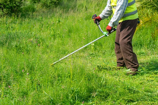 Der Gärtner mäht Gras per Rasenmäher, Rasenpflege — Stockfoto