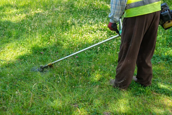 Der Gärtner mäht Gras per Rasenmäher, Rasenpflege — Stockfoto