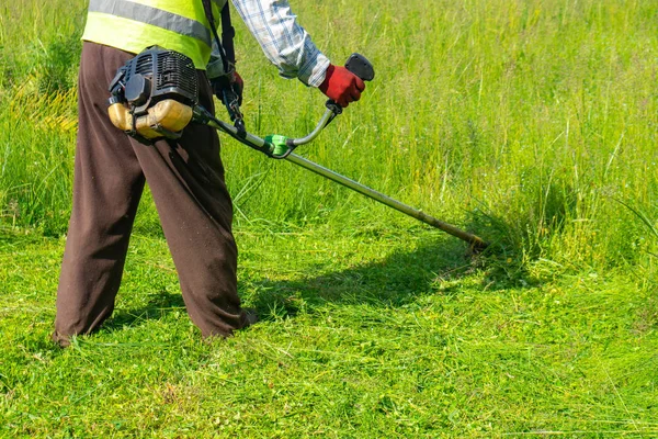 El jardinero cortando hierba por cortacésped, cuidado del césped — Foto de Stock