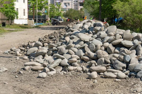 Montón de piedras redondeadas apiladas en el lado de la carretera. piedras para — Foto de Stock
