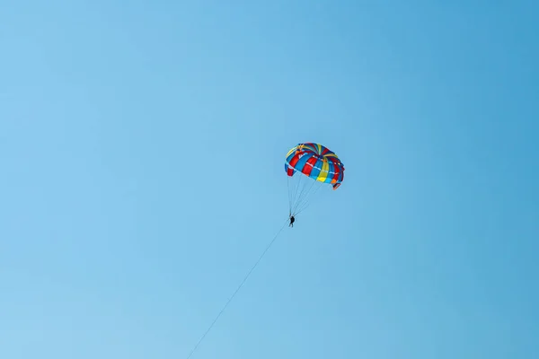 Управляемый парашют летит высоко в голубом небе — стоковое фото