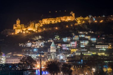 Eski Tiflis'in gece manzarası. Narikala Kalesi ve diğer simgesel yapılar