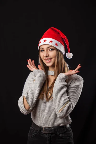 Beautiful girl posing on the black background in red New Year outfit. — Stock Photo, Image